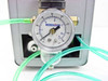 Close-up of Wilkerson pressure regulator and gauge on Ultramation OA-4 showing 0–160 psi dial gauge with clear bowl moisture separator and green tubing connections