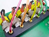Close-up of six Clippard ETO-3M 12 VDC solenoid valves mounted side by side on manifold block with color-coded wiring