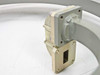 WR-62 rectangular waveguide flange end showing open aperture, four bolt-hole mounting pattern, and brass body with light surface patina