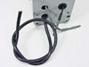 Close-up of Hoffman E-2PB833NM wiring leads — black and gray cables exiting the enclosure base with visible wire labels
