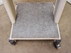 Bottom shelf of rolling cart — top-down view showing carpeted surface and caster bases at all four corners