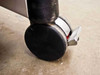 Close-up of one rubber caster wheel showing locking brake tab — wheel condition visible