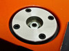 Microscope mount adapter plate — round stainless steel plate approximately 3 inches diameter with four bolt holes and center hex fitting, mounted on orange stage surface
