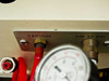 Side pneumatic panel label showing VACUUM port and AIR 40 PSI port with brass fittings and red vacuum hose