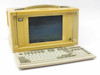 Novell LNalyzer BSI 386DX-33 portable lunchbox PC — three-quarter front view with keyboard deployed, unit powered on showing DOS text on screen
