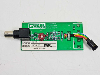 Guzik C201 Calibrator PCB front view showing Guzik label, model C201, serial 909F, BNC connector, toroidal inductor, and ribbon cable header