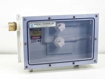 Fluoroware 201-35 chemical control valve assembly in sealed Systems Chemistry Inc. enclosure — front view with clear panel, two white valves and caution/danger labels visible