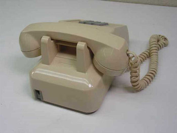 ITT Cortelco 250044-MBA-20M beige desk phone – rear three-quarter view showing handset cradle and coiled cord