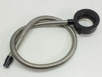 Fiber optic ring light illuminator full assembly view from opposite side — black anodized aluminum ring housing and stainless flex cable with input tip at bottom