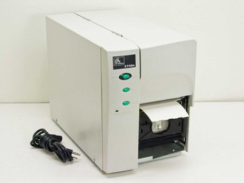 Zebra TLP2746E thermal label printer – front and left side view with power cable and label partially fed