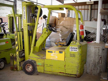 Clark TW30B 3-wheel electric forklift — left side view showing yellow painted body, mast, and forks in warehouse setting