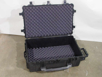 Waterproof rolling hard case open showing black egg-crate foam lid insert and waffle foam base insert inside