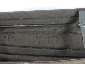 Interior of splint body canvas pouch showing traction bar and US military caduceus stamp reading NSN 6515-00-680-0887 Splint Wrap Around Leg Arm Back and Neck Canvas Part 1 of 3 Splint