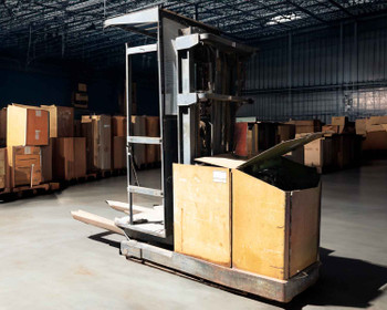Clark OP15 electric order picker forklift – right three-quarter view inside warehouse showing full mast height and battery compartment cover