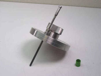 MDC vacuum flange side profile view showing flange body depth, center bore, and slender 1/4" fill port tube with green cap set aside nearby
