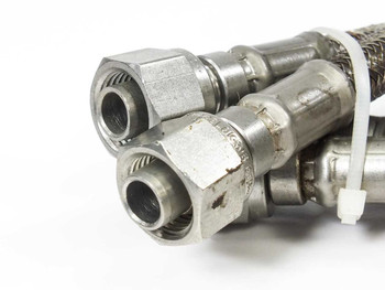 Swagelok SS-FM4SL4SL4-23 braided hose pair – close-up of 1/4-inch Swagelok tube fitting ends showing surface oxidation and label remnants