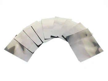 Solopower SP3 flexible solar cells fanned out showing the bare stainless steel substrate reverse side — highly reflective metallic backing