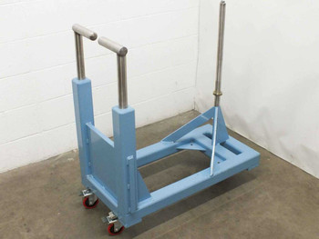 Blue steel rolled material handler dispenser cart – left front three-quarter view showing caster base, support frame, and stainless push handle assembly