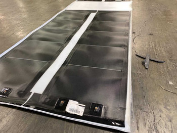 Xunlight XRS5-42 42W flexible amorphous solar panel — close-up of untrimmed panel sheet showing amorphous cell surface, white border framing, and label/barcode tags at bottom edge