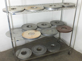 Lot of 13 Lapmaster 16-inch lapping and polishing plates on wire shelving rack — overview of all disks