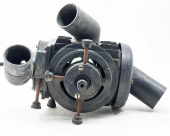 Vintage industrial lamp housing rear view showing blower fan disc, adjustable leveling feet, and dual elbow air duct ports