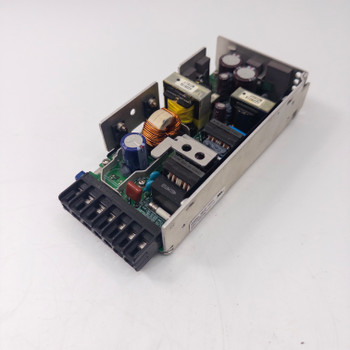 Omron S8VM-15024 open-frame switching power supply – angled top view showing PCB, toroidal inductor, heatsink fins, and output terminal block