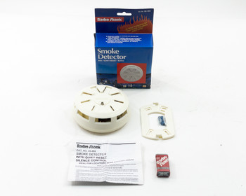 Radio Shack 49-466 Smoke Detector with original box, mounting bracket, instruction manual, and 9V battery laid out on white background