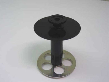 Epson ABS label printer media spool — top view showing black ABS plastic upper disc with toothed gear hub and metal base flange with four oval cutouts