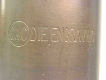 Close-up of embossed C&C Die Engraving brand logo on the rotary die roll body