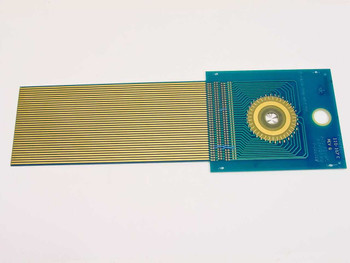 110-147C Rev G DAS Device PCB reverse side view showing gold finger flex ribbon extending left and radial contact array visible on right side of teal board