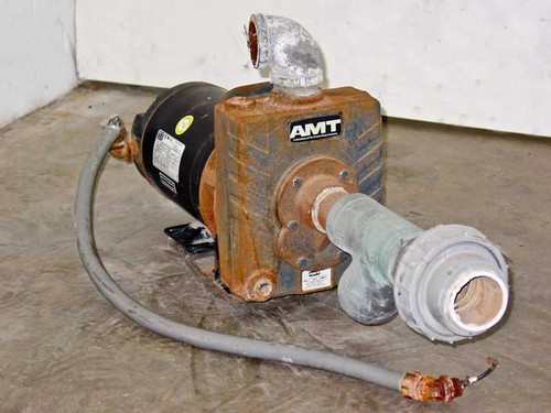 AMT 2822-95 self-priming centrifugal pump with WEG motor, front-left view showing pump body, discharge elbow, and attached piping