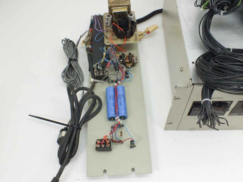 Internal circuit board from vacuum pump power distribution unit showing transformer, blue 6300uF 100VDC electrolytic capacitors, and wiring harness — top-down view