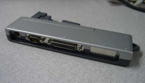 Toshiba PA2728U I/O Adapter Port replicator bar — angled view showing DB9 serial, DB25 parallel, and PS/2 connectors alongside the docking edge connector