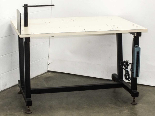 Lab tech bench work table with white steel top, black welded frame, vertical post with arm, and power strip mounted to right leg — front three-quarter view
