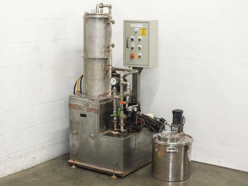 Stainless steel effluent treatment system full unit view with vertical tower, control panel, piping, and collection basin