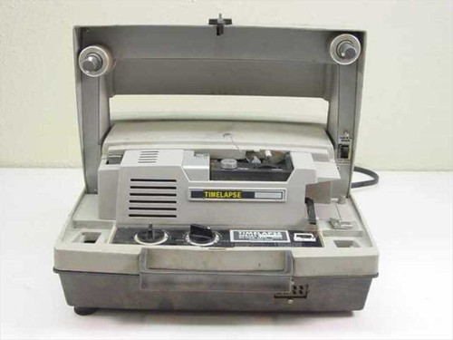 Timelapse 8mm movie film projector — top/front view with lid open showing film transport mechanism and projector head inside clamshell carrying case