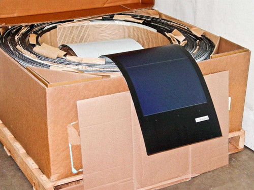 Uni-Solar PVL-136 flexible solar panel displayed leaning against carton of 30 panels coiled on pallet in large cardboard box