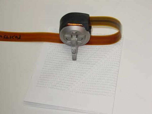 Fujitsu DX200 9-pin dot matrix printhead assembly with orange flat ribbon cable, shown printing on paper — front and side view