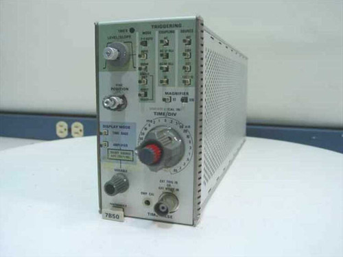 Tektronix 7B50 100MHz Timebase Plug-In front panel showing Time/Div knob, Triggering controls, Display Mode selector, and Magnifier switch — angled left view