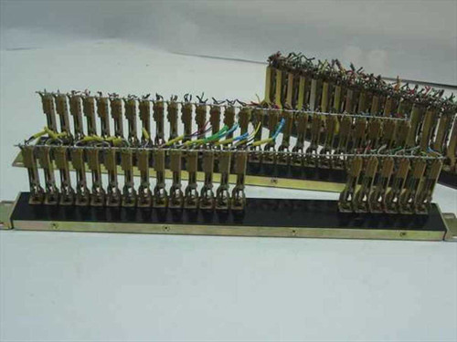 Close-up angled view of two PBX rackmount gold connector blocks showing gold terminal pins and multicolor wiring