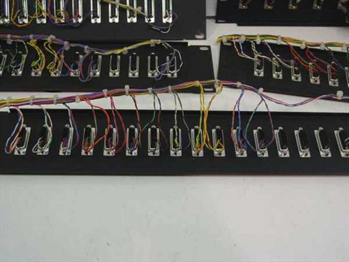 Close-up of DB25 serial connectors and attached multicolor wiring harnesses on rackmount panels