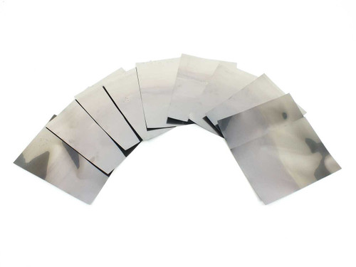 Solopower SP3 flexible solar cells fanned out showing the bare stainless steel substrate reverse side — highly reflective metallic backing