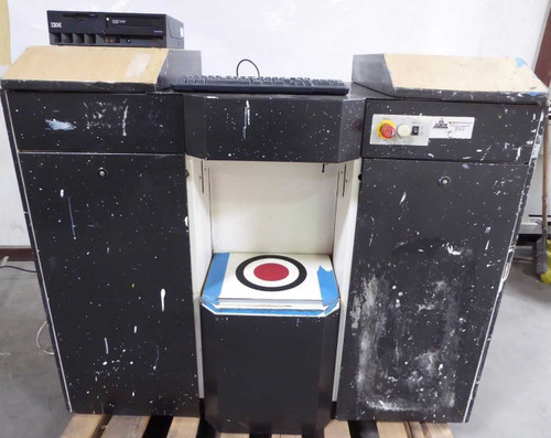 Corob AC10000 paint color mixing dispenser front view showing three-section black cabinet with open center dispensing bay, keyboard on top, IBM PC unit visible at top left, on pallet