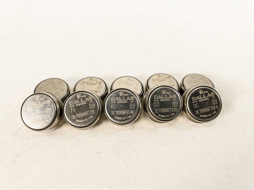 Lot of 10 Dallas Semiconductor DS1982U-F5 iButton stainless steel disk EPROM data carriers arranged in two rows on white surface