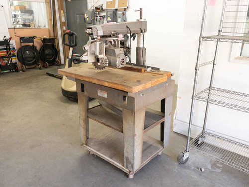 DeWalt 7790 radial arm saw with work table – left-side view in warehouse environment