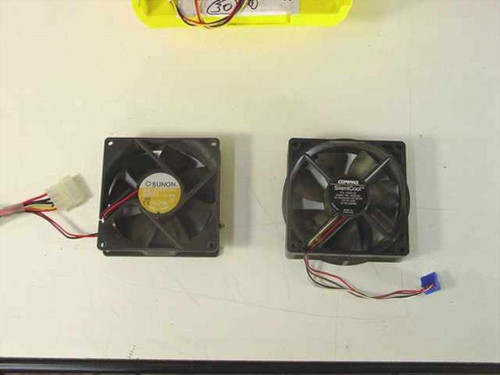 Close-up of two 80mm case fans side by side — left: Sunon with yellow label, right: Coprinus SilentCool — showing fan blade detail and connector leads