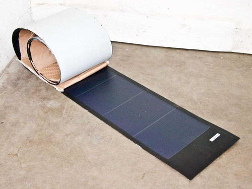 Uni-Solar PVL-136 flexible solar panel partially unrolled on concrete floor showing flexible laminate construction