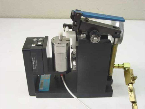 Daedal pneumatic clamp assembly right side view showing Daedal Inc label on black module, blue lever, pneumatic cylinder, and brass fittings