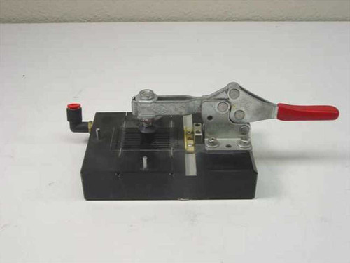 Pneumatic toggle clamp fixture assembly – left-side view showing red-handle toggle clamp over black aluminum base with push-in elbow air fitting