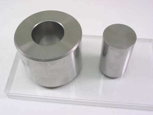 South Bay Technology die set — large hollow die body with matching cylindrical punch, shown side by side on clear acrylic tray